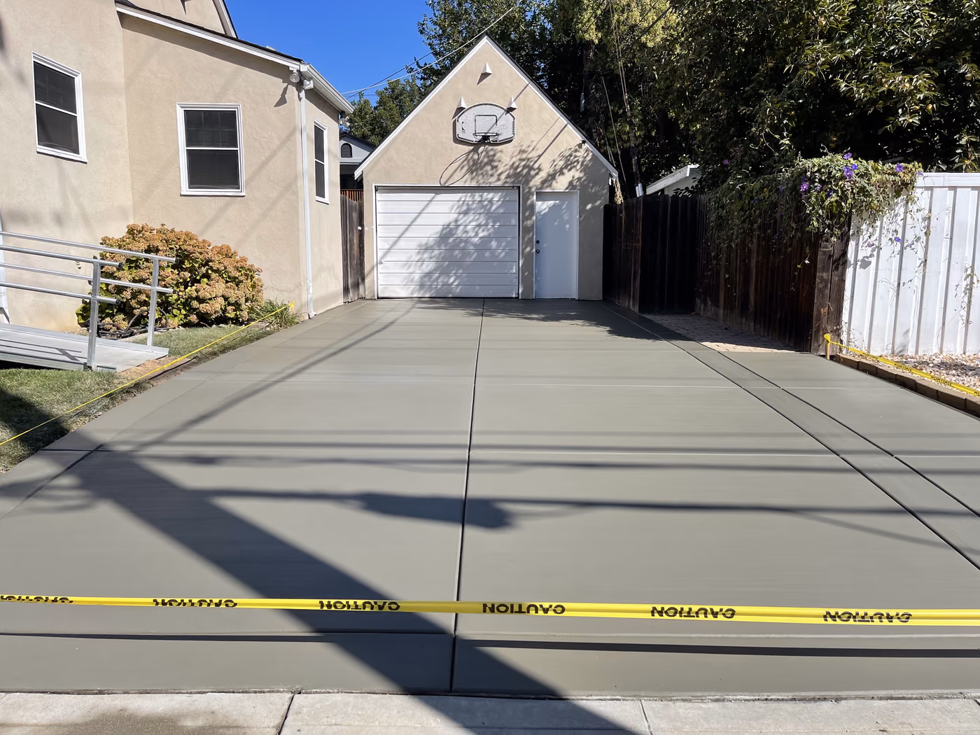 Finished wide concrete driveway to a detached garage