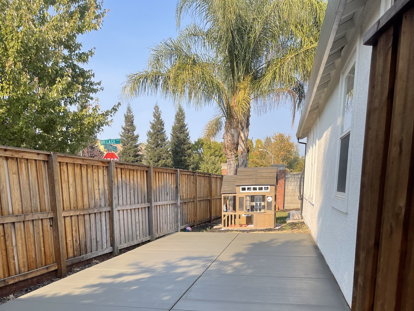 Finished concrete side yard running along a fence line