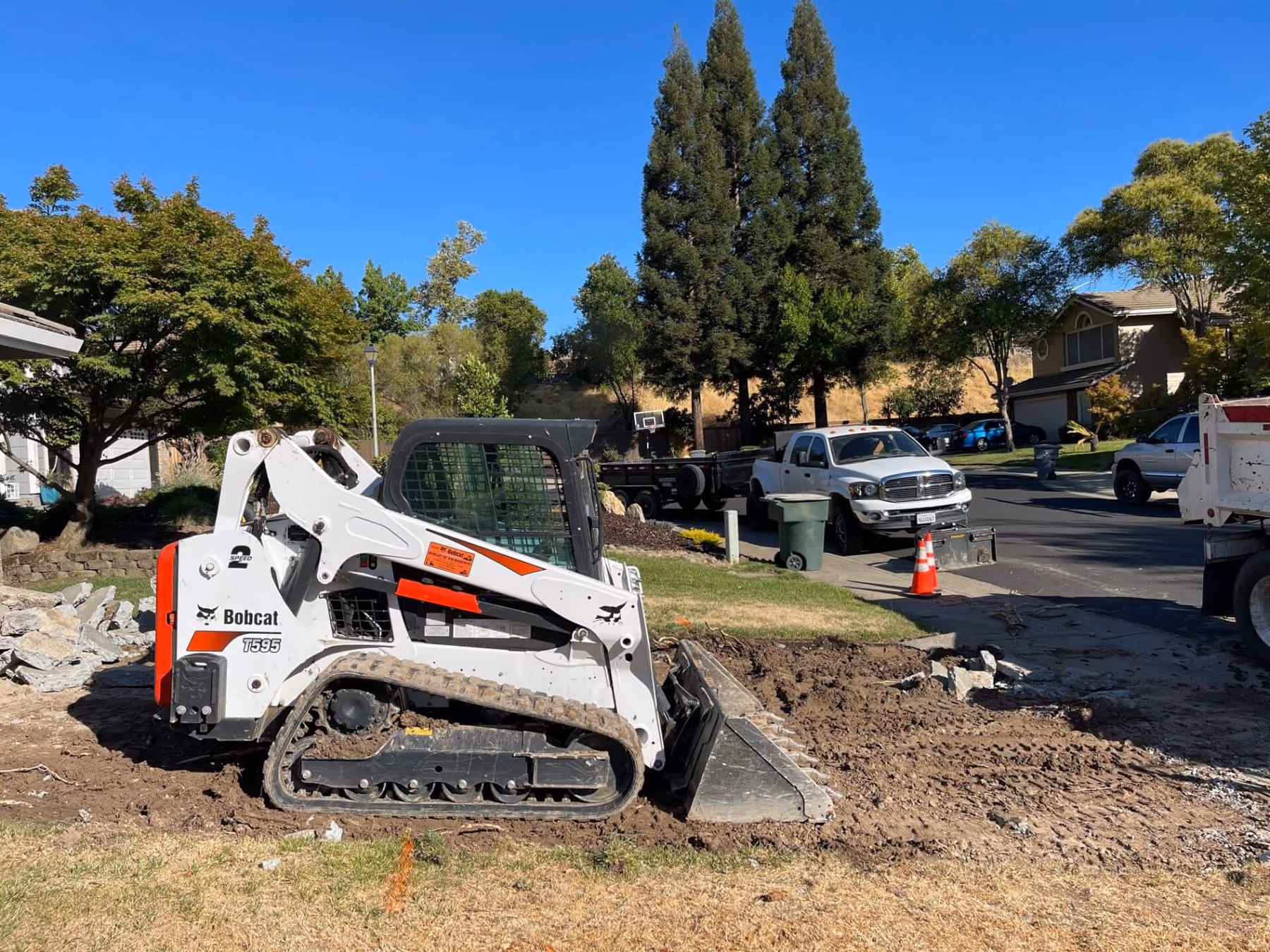 Skid steer grading ground level before a concrete pour in Sacramento